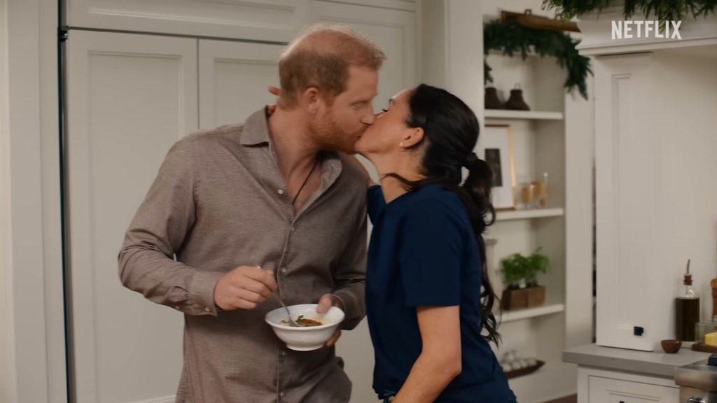 Meghan Markle kisses Prince Harry in their kitchen during the With Love, Meghan: Holiday Celebration teaser.
