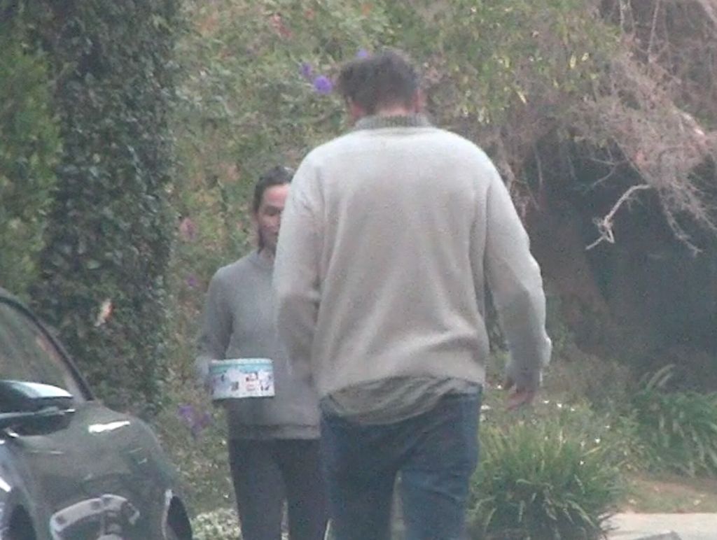 Garner and John Miller exchange holiday gifts by their cars in Los Angeles.
