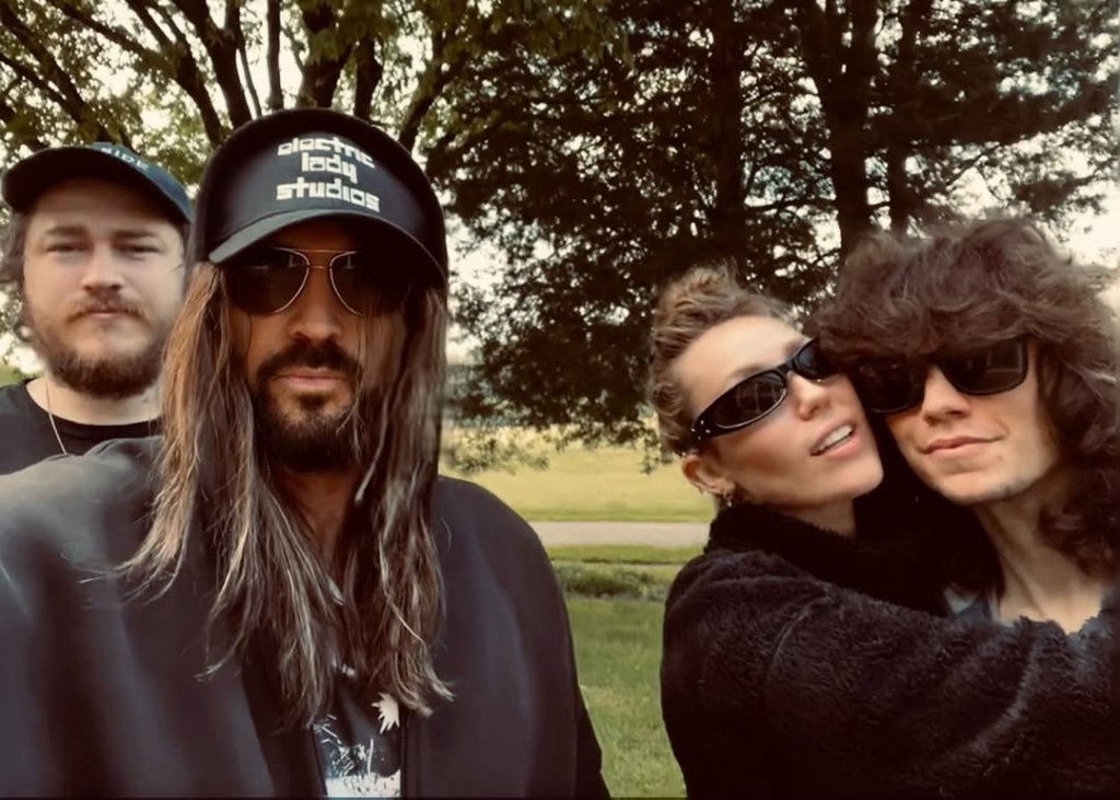 Miley Cyrus, Maxx Morando, Billy Ray Cyrus, and Braison Cyrus pose for a photo.