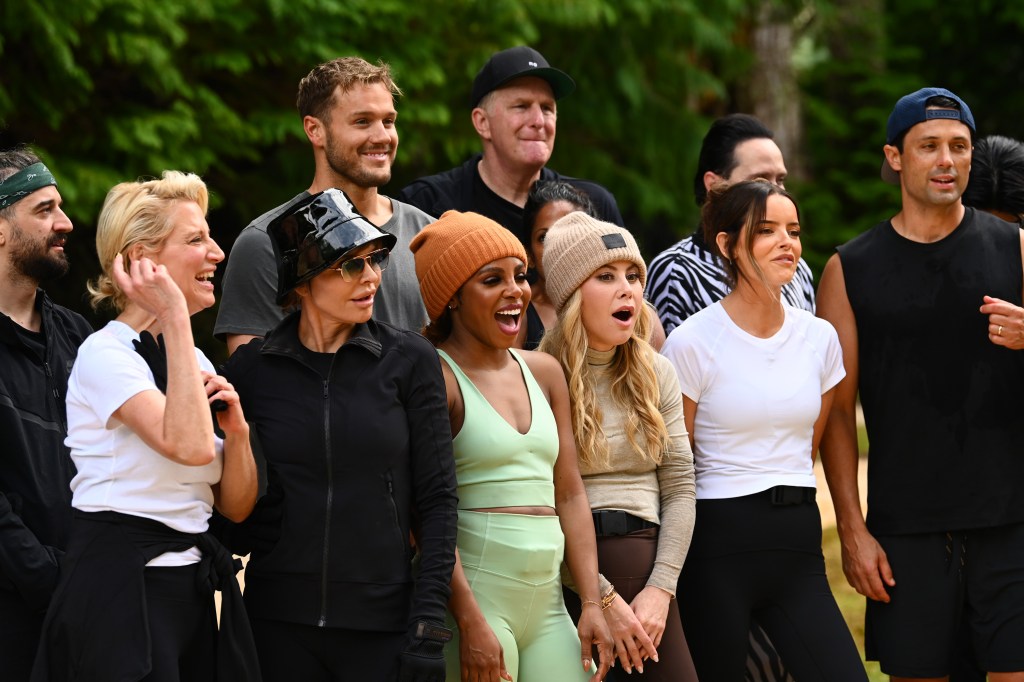 The Traitors cast, including Lisa Rinna and Colton Underwood, posing outdoors.