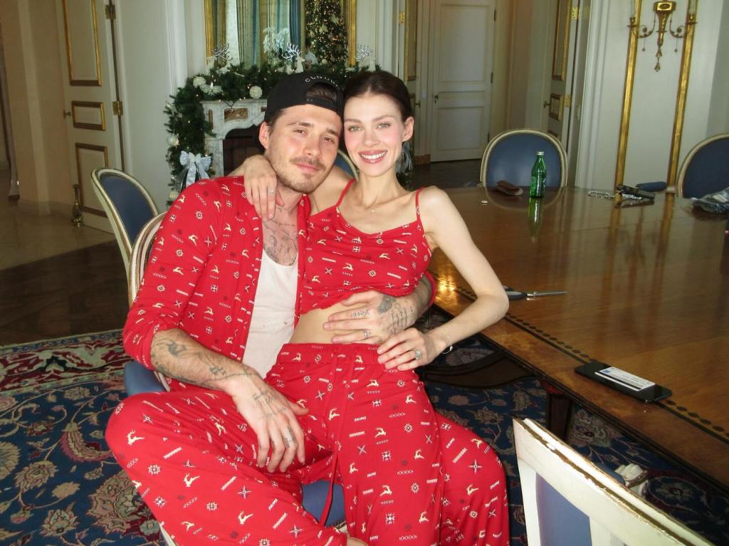 Nicola Peltz and Brooklyn Beckham in matching red Christmas pajamas.