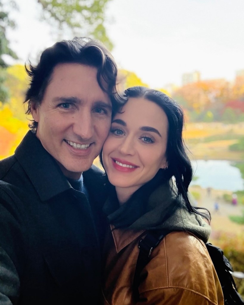 Katy Perry and Justin Trudeau posing together with a natural landscape in the background.