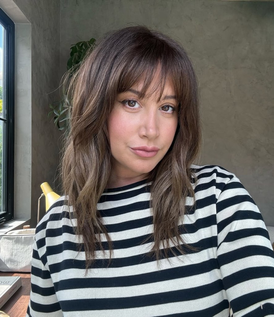 Ashley Tisdale wearing a black and white striped shirt.