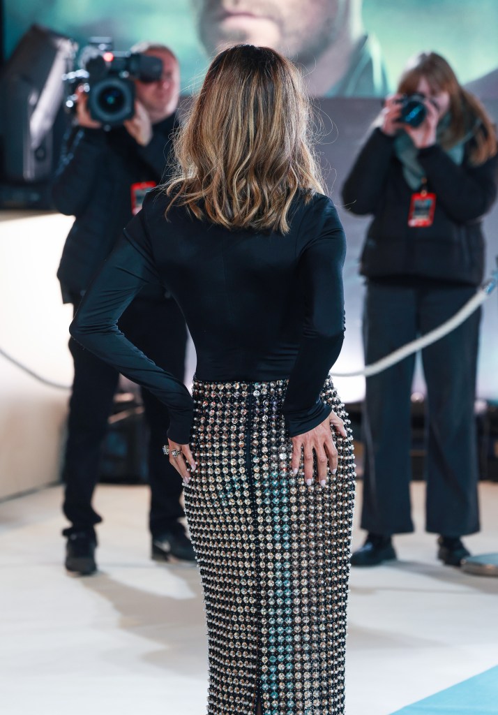 Halle Berry on the red carpet wearing a black long-sleeved top and shimmering, floor-length skirt.