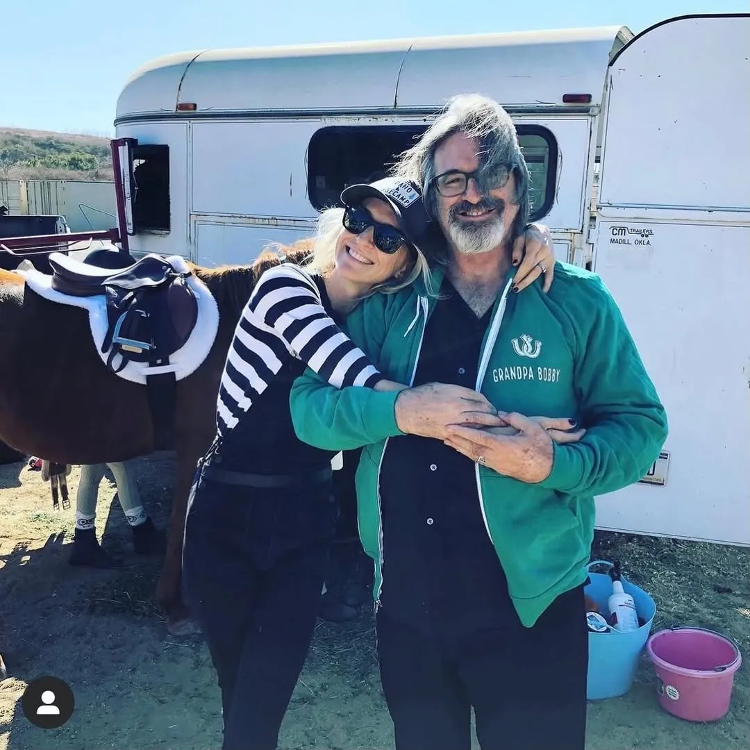 Ever Carradine embraces her father Robert Carradine outdoors.