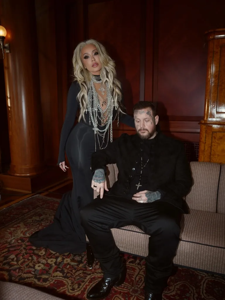 Bunnie XO standing behind Jelly Roll, who is seated.