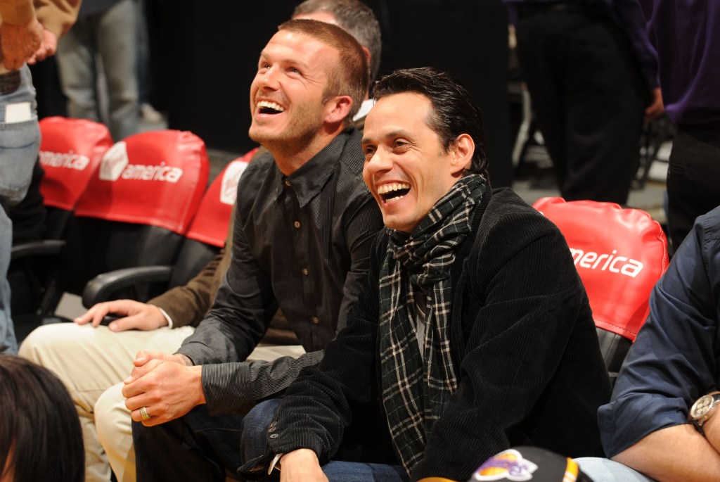 Marc Anthony and David Beckham share a laugh courtside, reflecting their longtime friendship.