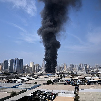 A black plume of smoke rises from a warehouse at the industrial area of Sharjah City in the United Arab Emirates - Daily Mail