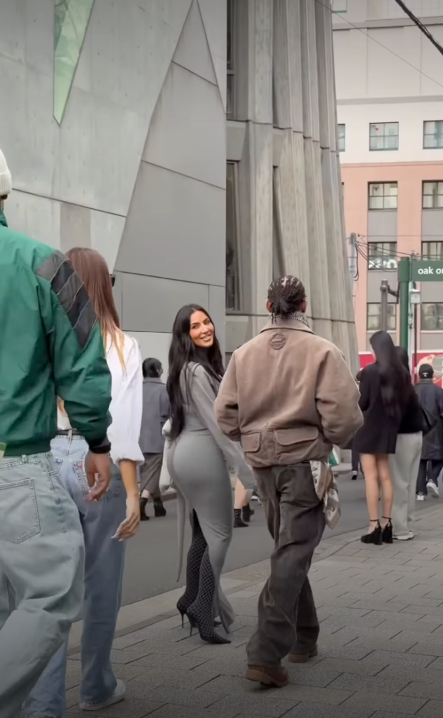 Kim Kardashian and Lewis Hamilton walking arm-in-arm in Tokyo as Khloe Kardashian follows a few steps behind.