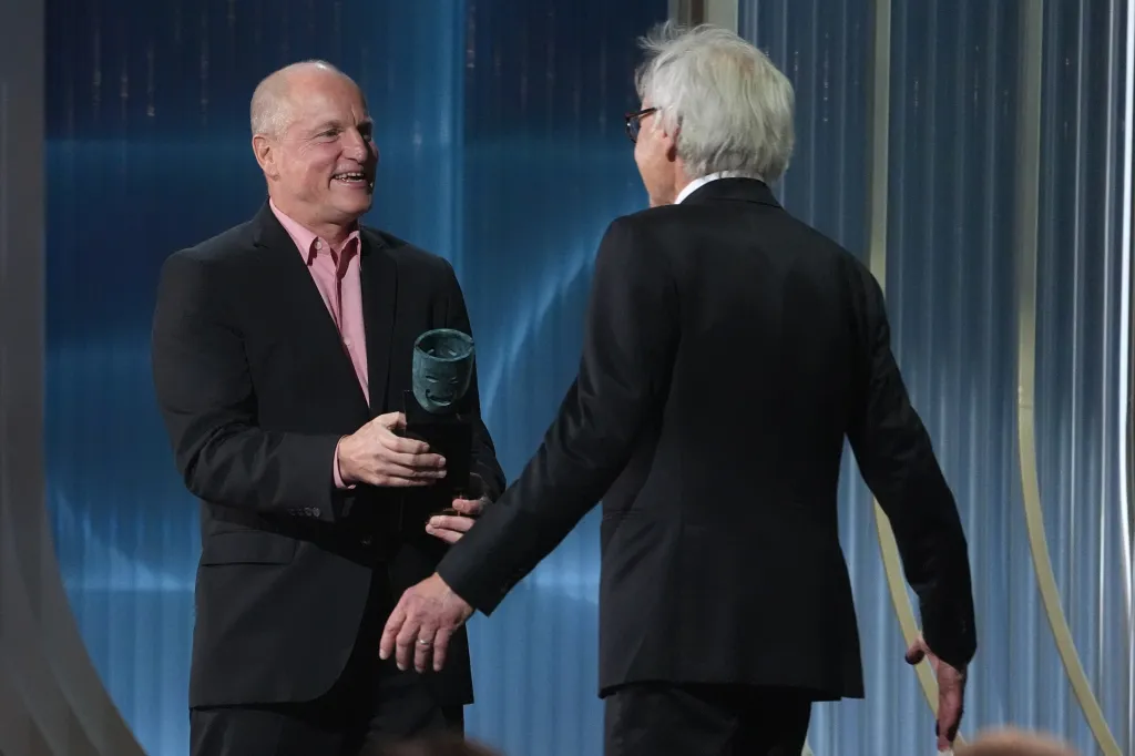 Woody Harrelson presents the SAG-AFTRA Life Achievement Award to Harrison Ford on stage.