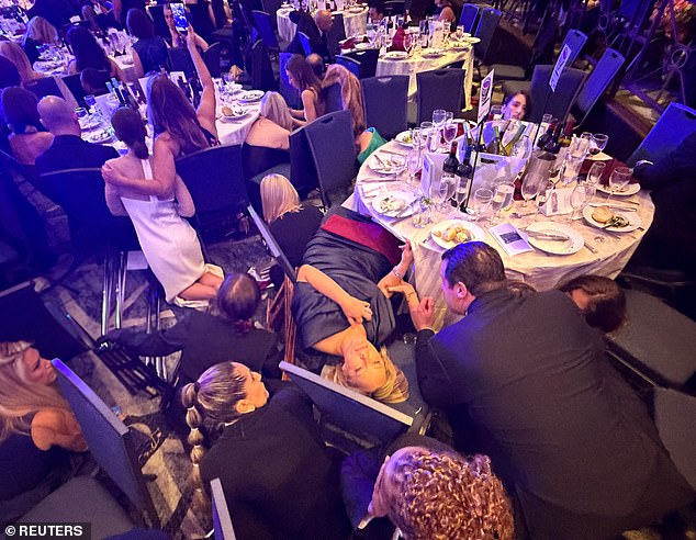 Guests duck for cover on the ballroom floor at the Washington Hilton during the White House Correspondents' Dinner.