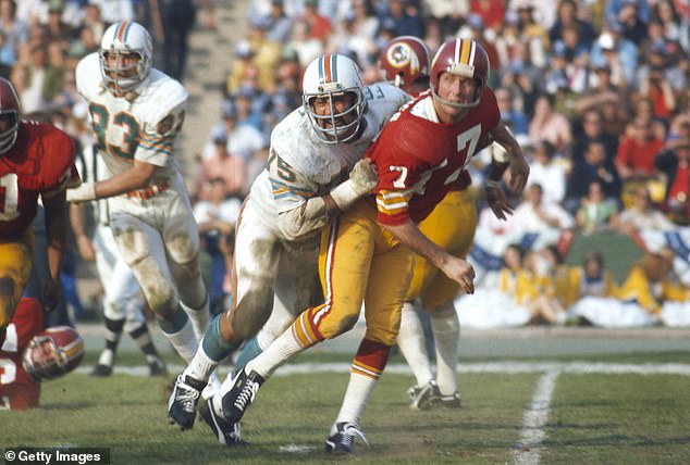 Washington quarterback Billy Kilmer releases a pass under pressure from Dolphins defensive tackle Manny Fernandez in Super Bowl VII