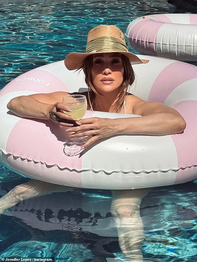 Jennifer Lopez lounges on a pool float in a white bikini during her Memorial Day pool day.