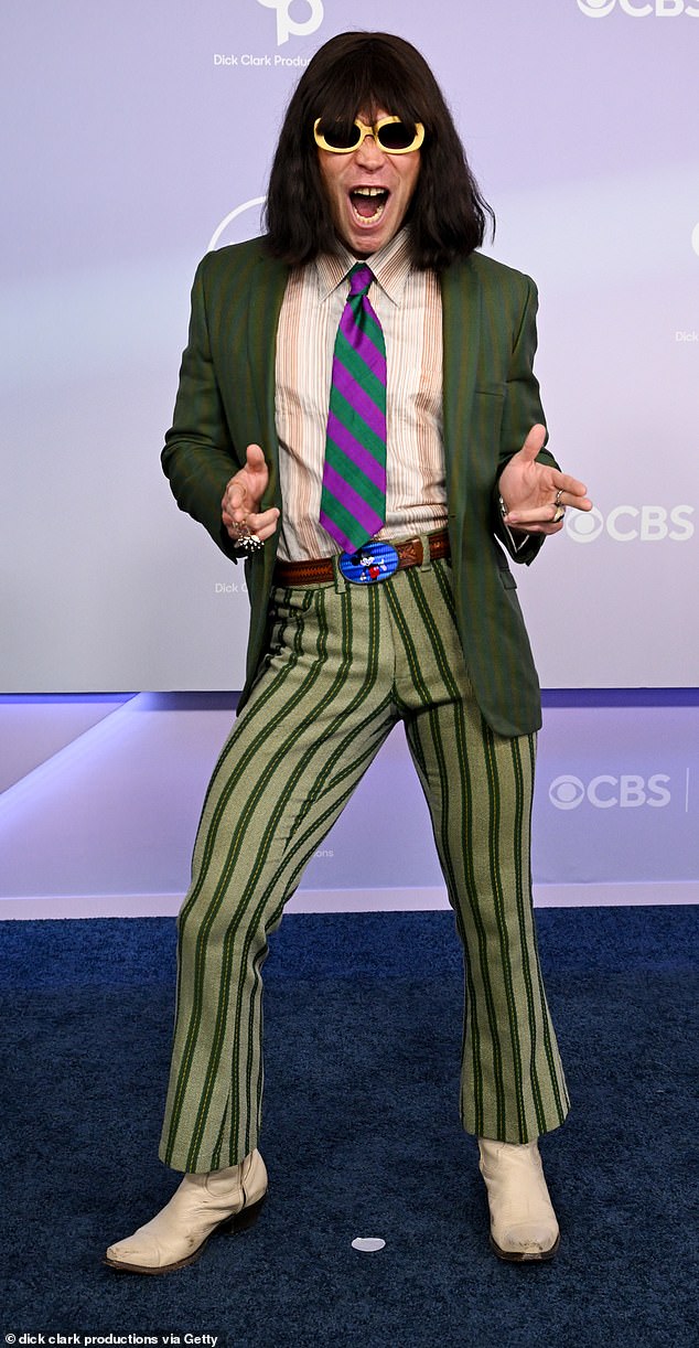 Viral performer Mr Fantasy in a green striped suit with a contrasting tie on the AMAs 2026 red carpet.