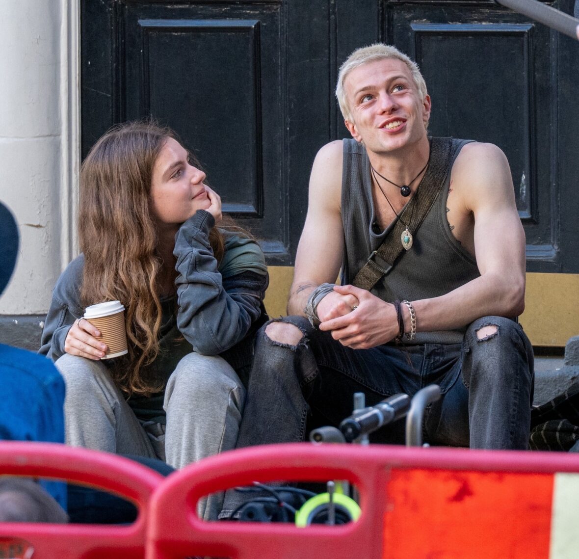Florence Hunt and Ruaridh Mollica sit together on the Bare set, smiling between takes in London