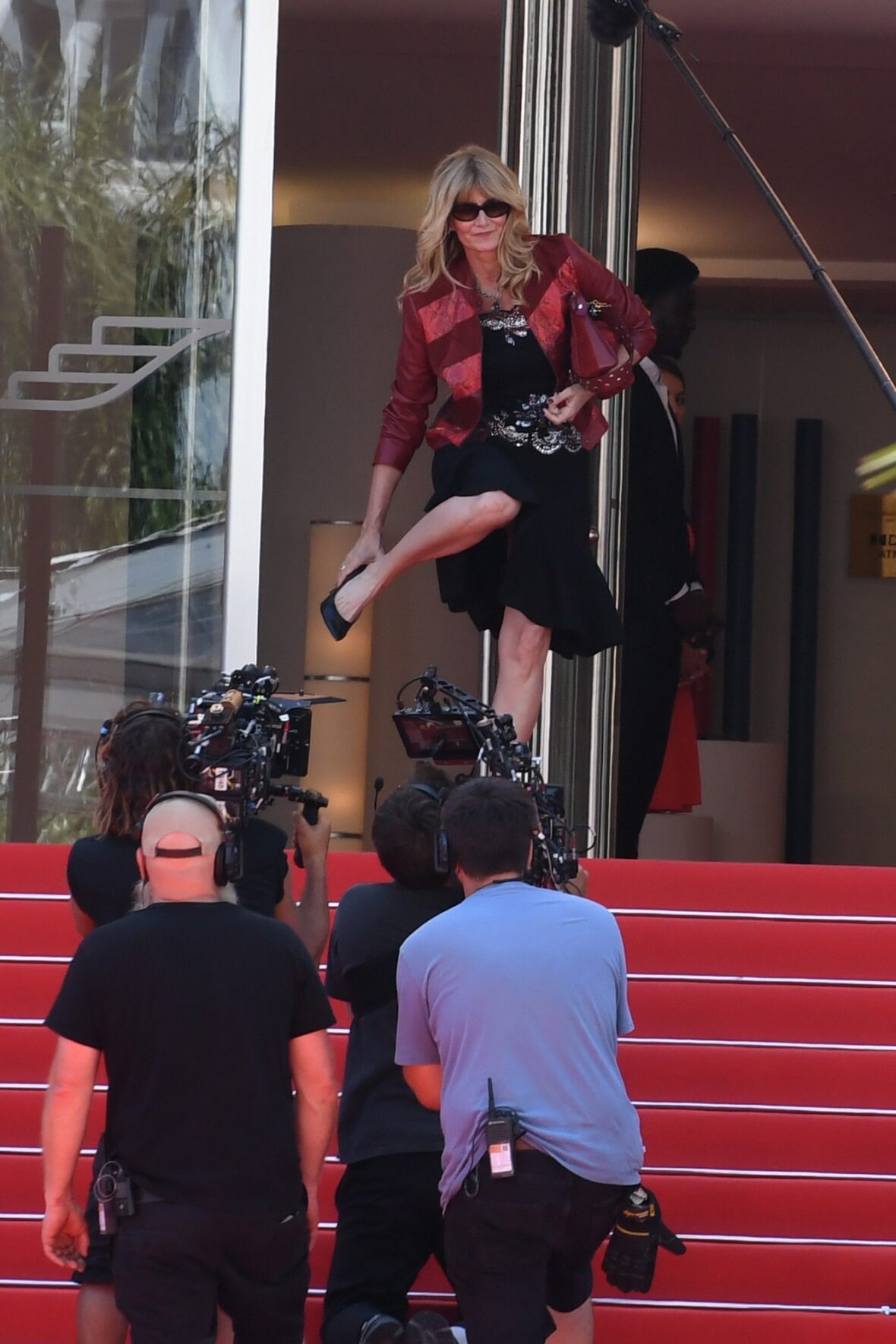 Cameras and crew surround Laura Dern on the Palais des Festivals steps during White Lotus filming.