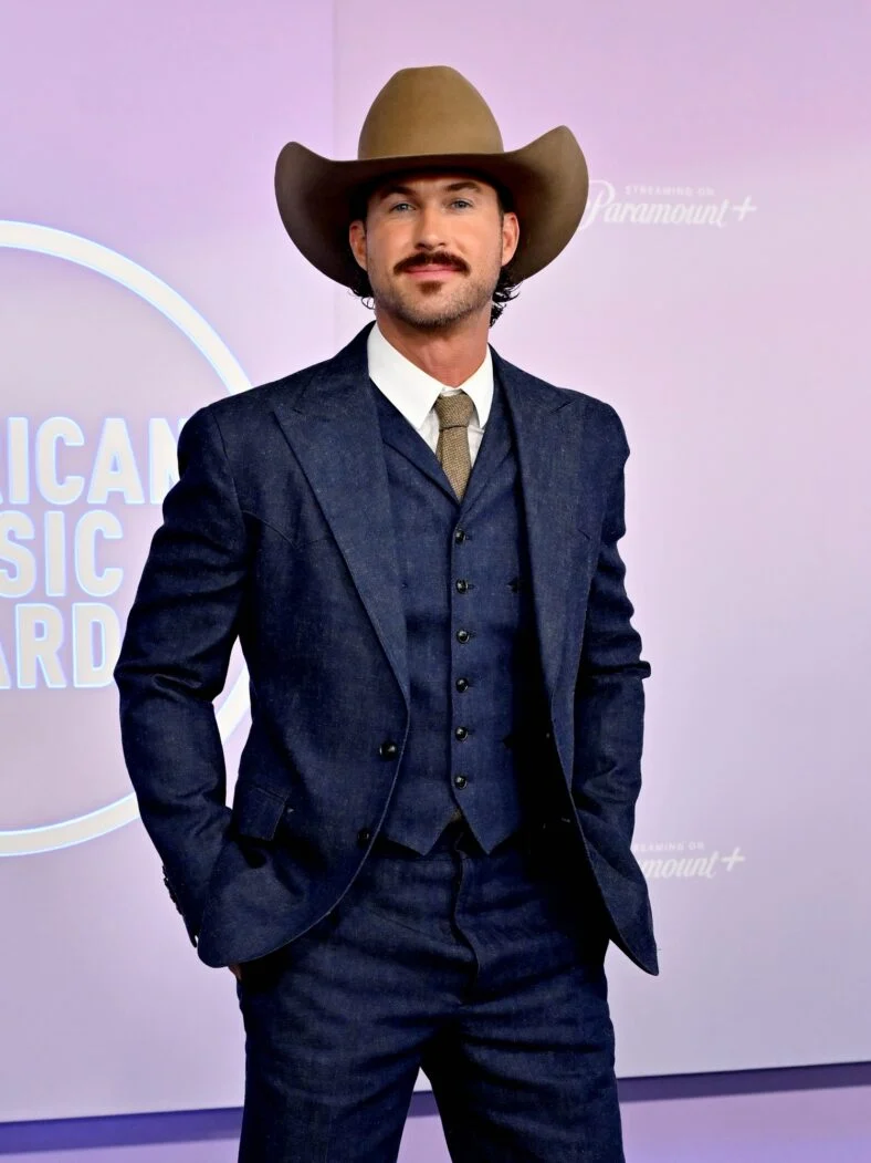 Riley Green poses on the American Music Awards step-and-repeat ahead of his performance