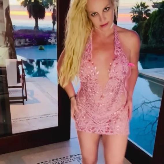 Britney Spears donned a plunging hot pink and lace mini dress for her latest Instagram dancing video (as seen above). - Instagram/britneyspears