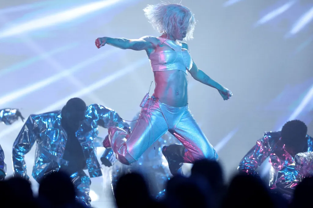 Teyana Taylor leaps onstage in metallic silver during her "All of Your Heart" performance at the 2026 AMAs.