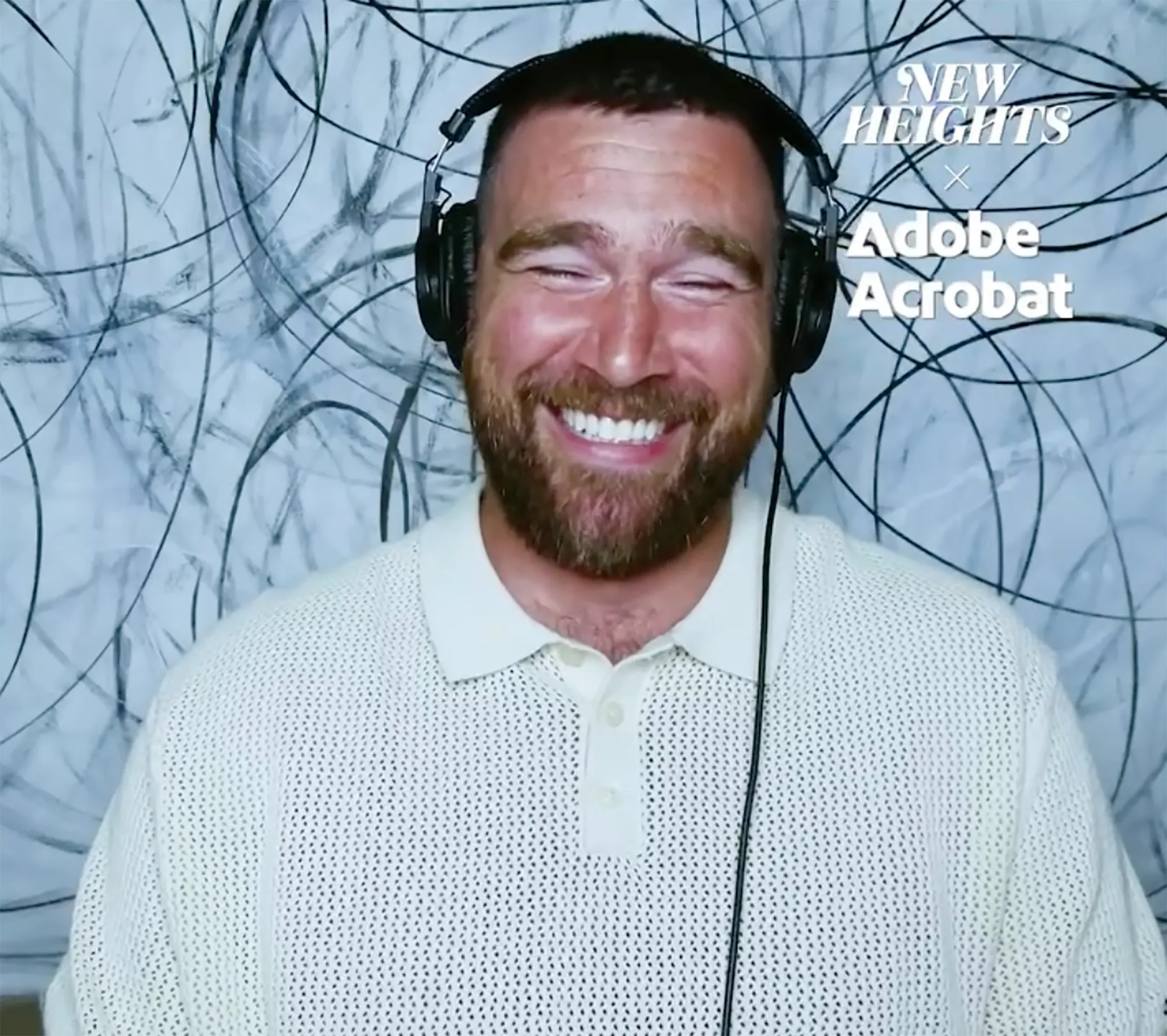 Travis Kelce on the New Heights podcast, smiling during a conversation about weddings with Rory McIlroy.