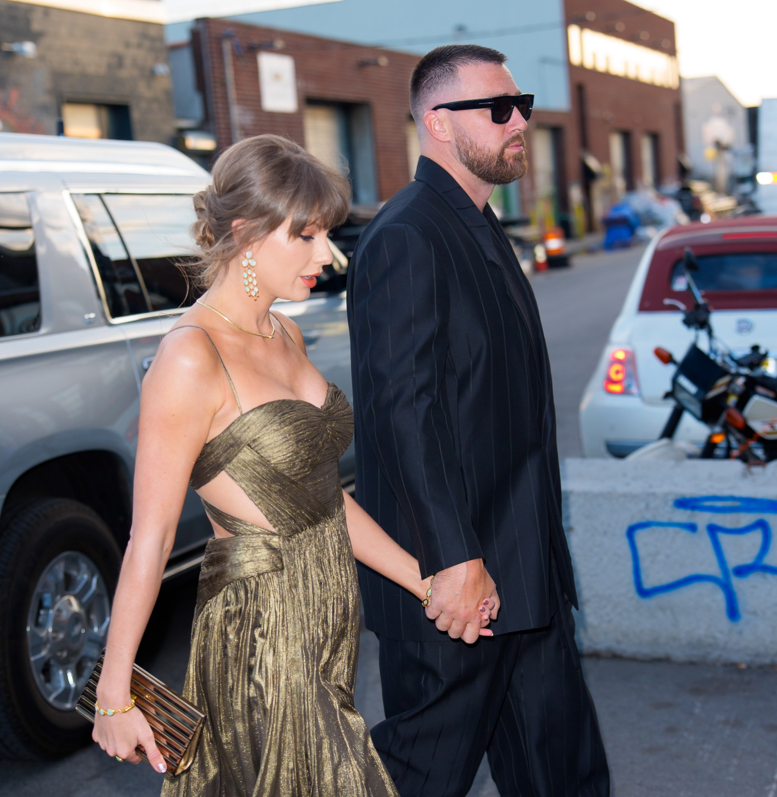After dinner, Taylor Swift wears Travis Kelce's blazer as they leave hand-in-hand in Brooklyn.
