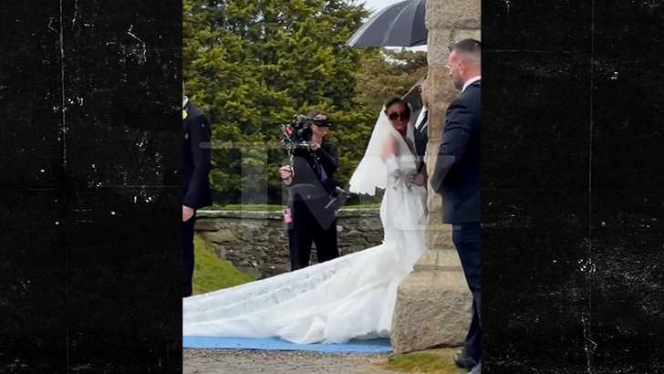 Venezuela Fury arriving at her Isle of Man wedding in the rain as attendants manage her long train.