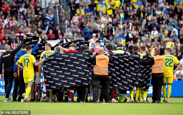 Denmark players and staff form a privacy screen around Christian Eriksen during a reported on-field medical emergency in Odense on June 8.