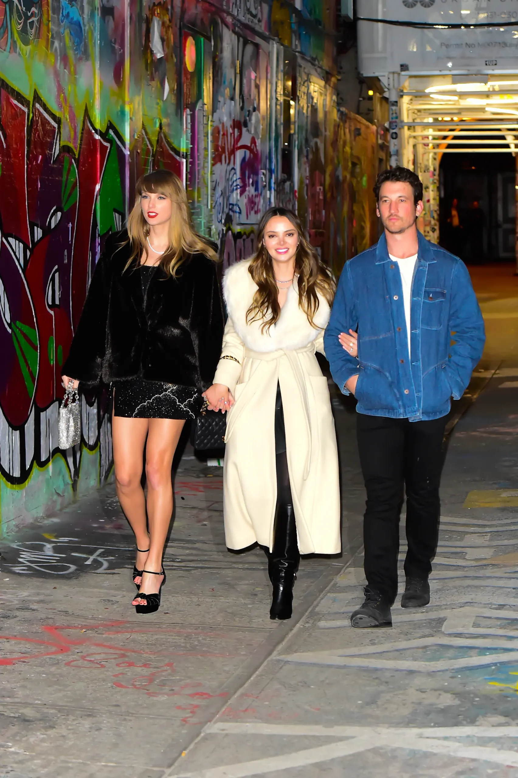 Taylor Swift walks with Keleigh Sperry and Miles Teller in December 2023.